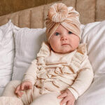 Dit leuke turban Velvet Beige komt uit de collectie van May Mays. Het mutsje is gemaakt van effen velvet stof  in de kleur champagne en een prachtige knoopdetail. Deze knoop zorgt voor een modieuze flair aan het outfitje van jouw kleine meid. Doordat het gemaakt is van katoen met elastaan zijn de mutsjes enigszins rekbaar. De eigentijdse uitstraling en het comfortabele ontwerp maken dit mutsje tot een onmisbaar accessoire voor jonge fashionista's.