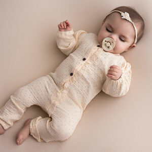 Dit leuke zalmkleurige boxpakje met lange mouwen komt uit de Amour collectie van Frogs and Dogs. Het boxpakje is gemaakt van zacht katoen en heeft een leuk stipjespatroon in de kleur zwart. De sluiting heeft 3 knoopjes in de vorm van een bloemetje en 2 drukkertjes. De zijkant van de opening heeft een schulprandje. De boorden van de mouwen en pijpjes zijn gezoomd met een elastiekje.