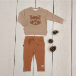 Dit leuke broekje in de kleur caramel komt uit de Raccoon Club collectie van Frogs and Dogs. Het broekje is effen van kleur. Zowel aan de voorzijde als aan de achterzijde zitten zakjes. De elastische tailleband is voorzien van een koordje. De boordjes van de pijpjes zijn gezoomd. Op het linkerpijpje aan de voorzijde zit het logo van de collectie gestikt.