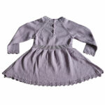 Deze mooie paarse jurkje komt uit de collectie Simply Nice Girl van Frogs and Dogs. Het jurkje heeft een wijd uitlopend rokje. Zowel de onderkant van het rokje als de onderkant van de mouwen hebben een gebreid rufflerandje met motief. Het jurkje heeft raglanmouwen met een gebreid motiefje op de naad. Op de achterzijde zit een sluiting met 3 knoopjes. 