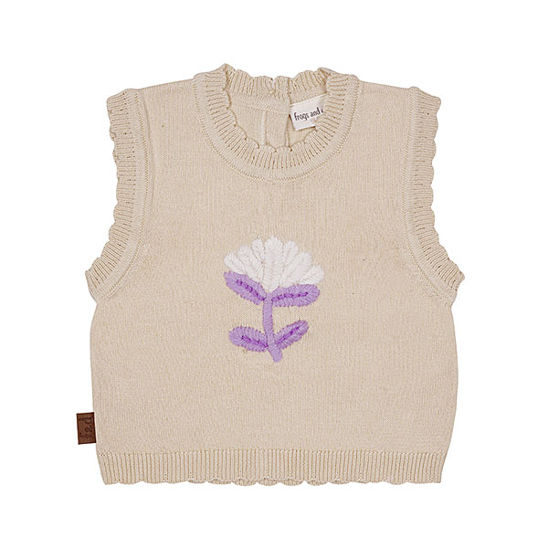Deze mooie beige spencer met geborduurde bloem komt uit de Simply Nice Girl collectie van Frogs and Dogs. De spencer heeft aan de hals, onderkant en de mouwgaten een gebreid rufflerandje. Op de achterzijde is een sluiting met 3 knoopjes. De geborduurde bloem is in de kleuren gebroken wit & paars.