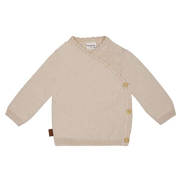 Dit mooie gebreide overslagshirtje met lange mouw is in de kleur beige en komt uit de collectie Simply Nice Girl van Frogs and Dogs. Het shirtje heeft een mooie overslag. De overslag heeft een gebreid rufflerandje. De boordjes zijn gebreid.