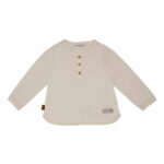 Een lief shirtje met lange mouw uit de collectie van Simply Nice Girl van Frogs en Dogs. Het blouse is gemaakt van mooie zachte stof en is effen van kleur met een leuk geweven motief. Het halsje en de mouwen zijn afgezet met een kanten randje. Het shirtje heeft aan de voorzijde een sluiting met houten knoopjes.