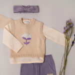 Een lief shirtje met lange mouw uit de collectie van Simply Nice Girl van Frogs en Dogs. Het blouse is gemaakt van mooie zachte stof en is effen van kleur met een leuk geweven motief. Het halsje en de mouwen zijn afgezet met een kanten randje. Het shirtje heeft aan de voorzijde een sluiting met houten knoopjes.