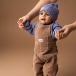 Dit leuke corduroy tuinbroekje in de kleur bruin is gemaakt van velvet ribstof komt uit de Smart Club collectie van Frogs and Dogs. Het tuinbroekje is effen van kleur en heeft aan de voorzijde 1 zakje met daarop het logo van de lijn. De banden zijn vastgemaakt met knoopjes. De pijpjes zijn gezoomd.