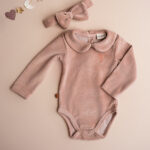 Dit mooie rompertje met lange mouw in de kleur roze smoke komt uit de collectie Paloma van Frogs en Dogs. Het rompertje is effen van kleur en heeft een schattig kraagje. Op de voorzijde zit het logootje - een vogel geborduurd. Op de achterzijde en tussen de beentjes zitten een drukkersluiting. 