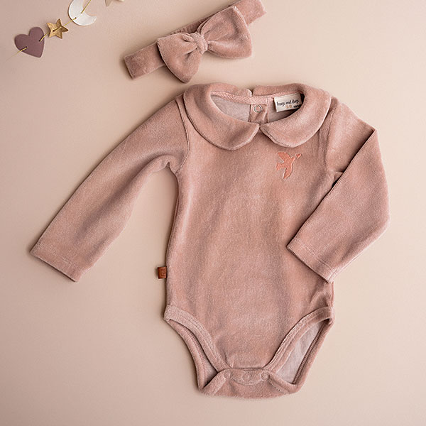 Dit mooie rompertje met lange mouw in de kleur roze smoke komt uit de collectie Paloma van Frogs en Dogs. Het rompertje is effen van kleur en heeft een schattig kraagje. Op de voorzijde zit het logootje - een vogel geborduurd. Op de achterzijde en tussen de beentjes zitten een drukkersluiting.