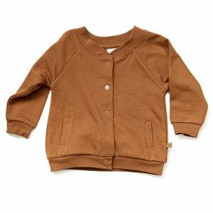 Een stoere camel kleurig bomber jasje met ronde hals en drukknopen is ideaal voor baby’s en dreumessen. Door de veilige en praktische drukknoopjes aan de voorkant kan het jasje gemakkelijk open en dicht. Ook zitten er twee steekzakken op het voorpand. Het jasje is gemaakt van een heerlijke stretch jersey met fleece. Waardoor het je kleintje warm houdt maar ook luchtig en mee stretch bij het aan en uit doen. De boord bij de nek en onderkant is gemaakt van rib stretch waardoor het jasje een bomber look krijgt.