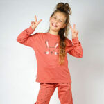 Deze leuke oudroze pyjama Bunny komt uit de collectie van Frogs and Dogs. Deze pyjama bestaat uit een shirt met lange mouwen en een broek met lange pijpen. Het shirtje heeft op de voorzijde een konijnenhoofdje in de kleuren roze en zwart. Op het broekje staat een overall print van zwarte hartjes. Deze serie heeft een verbeterde stofkwaliteit waardoor die mooier blijft na het wassen.