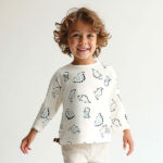 Peutershirt met lange mouw van Frogs and Dogs. Dino-print in groentinten, gebroken wit. Comfortabel en stoer, perfect voor actieve peuters!