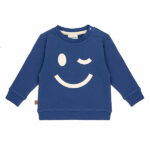 Deze stoere blauwe baby sweater met een grote, geprinte knipogende smile komt uit de collectie Happy With You van Frogs and Dogs. De print staat op de voorzijde en geeft een speelse en vrolijke uitstraling.