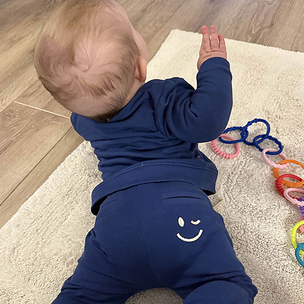 Stoere blauwe baby sweater met kleine smiley op borsthoogte voor een vrolijke touch. Gemaakt van zacht en warm materiaal, perfect voor frisse dagen.