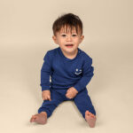 Donkerblauwe baby joggingbroek van Frogs and Dogs met geborduurde smiley. Zacht katoen, comfortabele pasvorm en perfect voor de zomer.