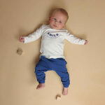 Donkerblauwe baby joggingbroek van Frogs and Dogs met geborduurde smiley. Zacht katoen, comfortabele pasvorm en perfect voor de zomer.