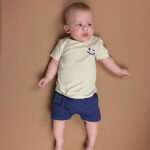 Blauw babybroekje van Frogs and Dogs met geborduurde smiley op de achterkant. Comfortabel, luchtig en perfect voor de zomer.