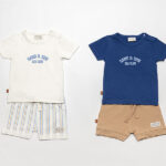 Donkerblauw baby t-shirtje voor jongens van Frogs and Dogs met korte mouwen, lichtblauwe Sea Club opdruk en schouderknoopjes.
