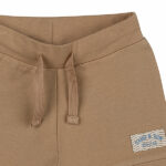 Dit mooie effen korte broekje in de kleur lichtbruin komt uit de collectie Sand and Sun van Frogs and Dogs. Het broekje heeft schattige boordjes aan de pijpjes en een comfortabele tailleband met een koord. Dankzij de neutrale kleur is het eindeloos te combineren met andere items. Als speels detail is het logo van de collectie subtiel op het pijpje gestikt.
