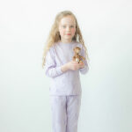 Deze leuke lila pyjama Giraffe komt uit de collectie van Frogs and Dogs.  Deze pyjama bestaat uit een shirt met lange mouwen en een broek met lange pijpen. De pyjama heeft een overall print van paarse giraffes. Deze serie heeft een verbeterde stofkwaliteit waardoor die mooier blijft na het wassen.