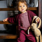 Dit licht roze met bordeaux streepjes baby t-shirt met lange mouwen en een ronde hals, is gemaakt van een comfortabele zachte rekbare katoen-lycra kwaliteit. De drukknoopjes op de schouder en de rek in de stof maakt dat de longsleeve gemakkelijk aan- en uit te trekken. De minimalistische en strakke lijnen in het ontwerp van het baby t-shirt met lange mouw en de eigenzinnige details, zijn zeer kenmerkend voor de collectie van Mijs X Merlijn. Door de prachtige kleuren combinatie in de streepjes van het shirt kan het mooi gecombineerd worden met de broekjes en vestjes van Mijs X Merlijn. 