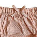 Deze lieve Bubble bloomer in de kleur zalmroze komt uit de Summer Flowers collectie van Frogs and Dogs. De bloomer is gemaakt van stof met een speels bubbeltjespatroon. De elastische tailleband zorgt voor een comfortabele pasvorm. Aan de voorzijde zit een schattig strikje. De zoompjes van de pijpjes hebben ingenaaide elastiek, wat zorgt voor een speelse rufflerand. Perfect voor zomerse dagen! De bloomer is een korte broek die je als 'onderbroekje' aantrekt over een luier. Als je kleintje een jurkje of rokje aan heeft dan zie je de luier niet. Voordeel is dat ze dan zelf de luier niet kunnen lostrekken.