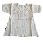 Deze prachtige Gold Glitter blouse uit de All Collection Summer van Frogs and Dogs straalt pure elegantie uit. Het blouseje is gemaakt van crèmekleurige stof met subtiele, gestippelde streepjes en een schitterende goudglitter. Op borsthoogte bevindt zich een gestikte rand met roze garen, net erboven zijn schattige hartjes geborduurd.