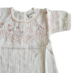 Deze prachtige Gold Glitter blouse uit de All Collection Summer van Frogs and Dogs straalt pure elegantie uit. Het blouseje is gemaakt van crèmekleurige stof met subtiele, gestippelde streepjes en een schitterende goudglitter. Op borsthoogte bevindt zich een gestikte rand met roze garen, net erboven zijn schattige hartjes geborduurd.