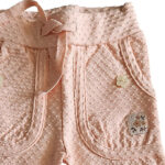 Dit lieve Bubble broekje in zalmroze uit de Summer Flowers collectie van Frogs and Dogs is gemaakt van een luchtige stof met een speels bubbeltjespatroon. Het heeft een elastische tailleband met koordje en opgestikte zakjes, afgewerkt met sierknoopjes in de vorm van bloemetjes. Perfect voor een zomerse, comfortabele look!