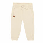Schattige beige joggingbroek uit de Happy with You collectie van Frogs and Dogs. Het broekje is gemaakt van heerlijk zacht katoen en zit supercomfortabel. De broek heeft twee steekzakjes aan de voorkant en twee nep kontzakjes aan de achterkant. Op een van de achterzakjes zit een geborduurde, blauwe smiley die ondeugend knipoogt — een speels detail!