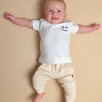Frogs and Dogs baby joggingbroek beige met geborduurde smiley op achterzakje uit de Happy with You collectie