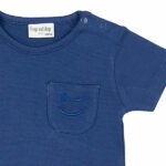 Dit schattige donkerblauwe t-shirt met korte mouwen komt uit de Happy with You collectie van Frogs and Dogs. Het shirtje heeft op borsthoogte een klein zakje, waar een knipogende smile is geborduurd – een vrolijke en speelse detail!  De schouder is voorzien van handige drukknoopjes, wat het aan- en uitkleden extra makkelijk maakt.