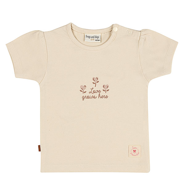 Dit lieve t-shirtje in de zachte tint Sheer Pink komt uit de Love Garden collectie van Frogs and Dogs. De kleur Sheer Pink is een subtiele beige tint met een vleugje roze. Op de voorzijde van het shirtje staat de tekst "Love Grown Here", met drie schattige bloemetjes. Tot en met maat 86 zitten er op de linkerschouder drukknoopjes, zodat het shirtje voor de kleintjes makkelijker aan- en uitgetrokken kan worden. De mouwtjes en onderkant zijn netjes omgezoomd, wat zorgt voor een mooie afwerking.