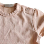 Dit lieve, zalmkleurige t-shirtje met korte mouwen komt uit de Love Garden collectie van Frogs and Dogs. Het t-shirtje is effen van kleur en de mouwtjes zijn speels gerimpeld aangezet. Op de schouder zit een handige drukknoopsluiting. De mouwtjes en onderkant zijn netjes omgezoomd, wat zorgt voor een verzorgde en stijlvolle afwerking.