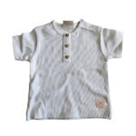 Dit lieve, witte t-shirtje met korte mouwen komt uit de Love Garden collectie van Frogs and Dogs. Het t-shirtje is effen van kleur en is gemaakt van fijne ribstof. Het t-shirtje heeft op de voorzijde een siersluiting met drie knoopjes in de vorm van een hartje. Op de schouder zit een handige drukknoopsluiting. De mouwtjes en onderkant zijn netjes omgezoomd, wat zorgt voor een verzorgde en stijlvolle afwerking.