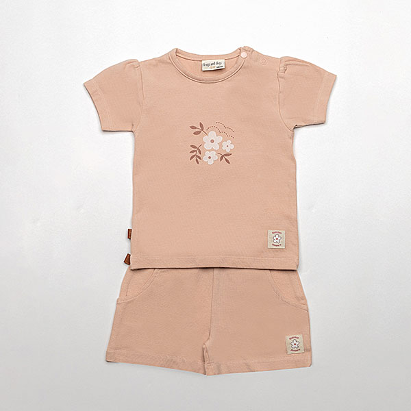 Dit schattige korte broekje of short in de kleur Rose Smoke komt uit de Summer Flowers collectie van Frogs and Dogs. Het broekje heeft een zachte, effen kleur en is gemaakt van een comfortabel materiaal dat perfect is voor warme zomerdagen. De elastische tailleband zorgt voor een fijne pasvorm en is voorzien van een stijlvol roze koord om de taille naar wens aan te passen. Daarnaast heeft het broekje twee handige steekzakjes aan de voorkant, ideaal om kleine spulletjes in mee te nemen. Een perfecte mix van stijl en comfort voor een zomerse look!