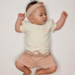 Dit schattige korte broekje of short in de kleur Rose Smoke komt uit de Summer Flowers collectie van Frogs and Dogs. Het broekje heeft een zachte, effen kleur en is gemaakt van een comfortabel materiaal dat perfect is voor warme zomerdagen. De elastische tailleband zorgt voor een fijne pasvorm en is voorzien van een stijlvol roze koord om de taille naar wens aan te passen. Daarnaast heeft het broekje twee handige steekzakjes aan de voorkant, ideaal om kleine spulletjes in mee te nemen. Een perfecte mix van stijl en comfort voor een zomerse look!