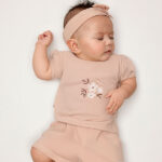 Dit schattige korte broekje of short in de kleur Rose Smoke komt uit de Summer Flowers collectie van Frogs and Dogs. Het broekje heeft een zachte, effen kleur en is gemaakt van een comfortabel materiaal dat perfect is voor warme zomerdagen. De elastische tailleband zorgt voor een fijne pasvorm en is voorzien van een stijlvol roze koord om de taille naar wens aan te passen. Daarnaast heeft het broekje twee handige steekzakjes aan de voorkant, ideaal om kleine spulletjes in mee te nemen. Een perfecte mix van stijl en comfort voor een zomerse look!