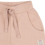 Dit schattige korte broekje of short in de kleur Rose Smoke komt uit de Summer Flowers collectie van Frogs and Dogs. Het broekje heeft een zachte, effen kleur en is gemaakt van een comfortabel materiaal dat perfect is voor warme zomerdagen. De elastische tailleband zorgt voor een fijne pasvorm en is voorzien van een stijlvol roze koord om de taille naar wens aan te passen. Daarnaast heeft het broekje twee handige steekzakjes aan de voorkant, ideaal om kleine spulletjes in mee te nemen. Een perfecte mix van stijl en comfort voor een zomerse look!