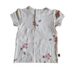 Dit lieve t-shirtje Flo in de zachte tint White Alyssum komt uit de Summer Flowers collectie van Frogs and Dogs. Het t-shirtje heeft een all-over print van bloemetjes. Op de voorzijde zitten 2 doorzichtige bloemknoopjes voor de sier. Op de achterzijde zit een drukknoop sluiting. Dit shirtje is een showmodel. Nooit aangehad het is een ontwerp design vandaar dat het als 2e hands verkocht wordt. 