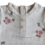 Dit lieve t-shirtje Flo in de zachte tint White Alyssum komt uit de Summer Flowers collectie van Frogs and Dogs. Het t-shirtje heeft een all-over print van bloemetjes. Op de voorzijde zitten 2 doorzichtige bloemknoopjes voor de sier. Op de achterzijde zit een drukknoop sluiting. Dit shirtje is een showmodel. Nooit aangehad het is een ontwerp design vandaar dat het als 2e hands verkocht wordt. 