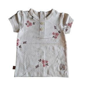 Dit lieve t-shirtje Flo in de zachte tint White Alyssum komt uit de Summer Flowers collectie van Frogs and Dogs. Het t-shirtje heeft een all-over print van bloemetjes. Op de voorzijde zitten 2 doorzichtige bloemknoopjes voor de sier. Op de achterzijde zit een drukknoop sluiting. Dit shirtje is een showmodel. Nooit aangehad het is een ontwerp design vandaar dat het als 2e hands verkocht wordt. 