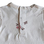 Dit lieve t-shirtje Flo in de zachte tint White Alyssum komt uit de Summer Flowers collectie van Frogs and Dogs. Het t-shirtje heeft een all-over print van bloemetjes. Op de voorzijde zitten 2 doorzichtige bloemknoopjes voor de sier. Op de achterzijde zit een drukknoop sluiting. Dit shirtje is een showmodel. Nooit aangehad het is een ontwerp design vandaar dat het als 2e hands verkocht wordt. 