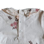 Lief t-shirtje Flo met lange mouw in de zachte tint White Alyssum uit de Summer Flowers-collectie van Frogs and Dogs. Voorzien van een all-over bloemetjesprint in roze en burlwood, een sierlijke rufflerand bij de hals en een praktische drukknoopsluiting op de achterkant. Netjes omgezoomd voor een verzorgde afwerking. Comfortabel en perfect voor zonnige dagen!