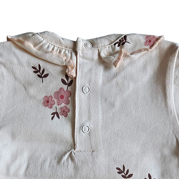 Lief t-shirtje Flo met lange mouw in de zachte tint White Alyssum uit de Summer Flowers-collectie van Frogs and Dogs. Voorzien van een all-over bloemetjesprint in roze en burlwood, een sierlijke rufflerand bij de hals en een praktische drukknoopsluiting op de achterkant. Netjes omgezoomd voor een verzorgde afwerking. Comfortabel en perfect voor zonnige dagen!