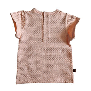 Dit lieve Bubble t-shirtje met korte mouwen in een zachte zalmroze kleur komt uit de Summer Flowers collectie van Frogs and Dogs. Het shirtje is gemaakt van een fijne, luchtige stof met een speels bubbeltjespatroon, wat zorgt voor een subtiele textuur en een extra schattige uitstraling. Een sierlijk strikje op de halsrand aan de voorzijde voegt een charmante en verfijnde touch toe. De gezoomde randen van de mouwtjes zijn afgewerkt met een elegant kanten randje, wat het geheel een romantisch en lieflijk karakter geeft. Aan de achterzijde is een handige drukknoopsluiting aangebracht, zodat het t-shirtje gemakkelijk aan- en uitgetrokken kan worden.