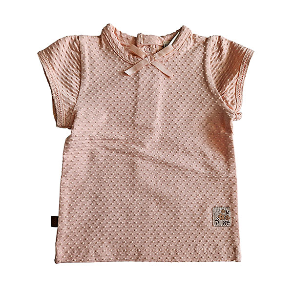 Dit lieve Bubble t-shirtje met korte mouwen in een zachte zalmroze kleur komt uit de Summer Flowers collectie van Frogs and Dogs. Het shirtje is gemaakt van een fijne, luchtige stof met een speels bubbeltjespatroon, wat zorgt voor een subtiele textuur en een extra schattige uitstraling. Een sierlijk strikje op de halsrand aan de voorzijde voegt een charmante en verfijnde touch toe. De gezoomde randen van de mouwtjes zijn afgewerkt met een elegant kanten randje, wat het geheel een romantisch en lieflijk karakter geeft. Aan de achterzijde is een handige drukknoopsluiting aangebracht, zodat het t-shirtje gemakkelijk aan- en uitgetrokken kan worden.