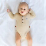 Dit zandkleurige rompertje met wafelstructuur komt uit de All Collection van Frogs and Dogs en is ideaal voor de zomer. Het is gemaakt van een zachte stof en heeft korte mouwen. De voorzijde is voorzien van een sluiting met drie knoopjes, en tussen de beentjes zit een drukknoopsluiting. Het rompertje kan los gedragen worden bij warm weer of gecombineerd worden met een vestje op koelere dagen.