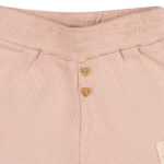 Deze schattige roze korte broek uit de Love Garden-collectie van Frogs and Dogs is een must-have voor elke garderobe. Gemaakt van zachte ribstof en uitgevoerd in een effen kleur, biedt dit broekje zowel stijl als comfort. De elastische tailleband zorgt voor een perfecte pasvorm, terwijl de twee sierknoopjes in hartvorm aan de voorkant een speelse touch toevoegen. De broekspijpjes zijn netjes omgezoomd voor een mooie afwerking.