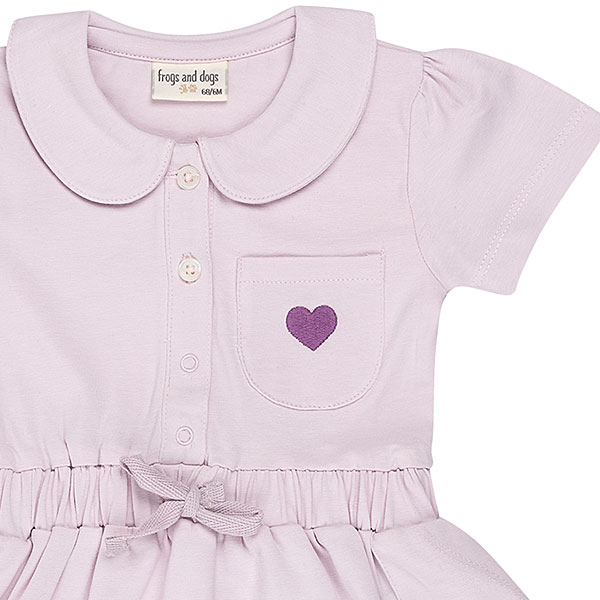Dit mooie jurkje in de kleur Lavender Fog komt uit de Beautiful Hearts collectie van Frogs and Dogs. Het jurkje heeft een schattig kraagje en een drukknoopsluiting aan de voorzijde. Op het borstzakje prijkt een paars geborduurd hartje. De mouwtjes zijn licht gepoft en het rokje heeft een speelse, gerimpelde zoom. In de taille bevindt zich een elastische rand met een strikje, wat de jurk een extra charmante uitstraling geeft. Het rokje is voorzien van 2 steekzakjes.