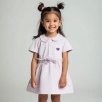 Dit mooie jurkje in de kleur Lavender Fog komt uit de Beautiful Hearts collectie van Frogs and Dogs. Het jurkje heeft een schattig kraagje en een drukknoopsluiting aan de voorzijde. Op het borstzakje prijkt een paars geborduurd hartje. De mouwtjes zijn licht gepoft en het rokje heeft een speelse, gerimpelde zoom. In de taille bevindt zich een elastische rand met een strikje, wat de jurk een extra charmante uitstraling geeft. Het rokje is voorzien van 2 steekzakjes.