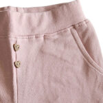 Dit schattige oudroze korte broekje - short - is perfect voor zomerse dagen. Het heeft een elastische tailleband, sierknoopjes en steekzakjes